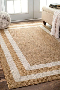 Beige and white striped rug on a wooden floor with a bench and window in the background.