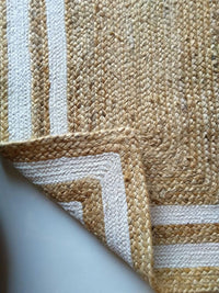 Close-up of a textured rug with a geometric pattern on a neutral background