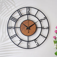 Decorative wall clock with black metal frame and wooden center on a white background