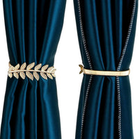 Gold leaf curtain tiebacks on teal curtains against a white background