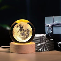Moon lamp on a wooden base with gift boxes in the background