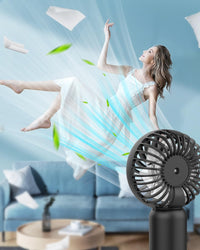 Woman in a white dress surrounded by a cloud of mist with a handheld fan in the foreground.