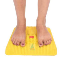 Yellow foot exercise board with feet on a white background