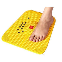 Yellow foot reflexology mat with a foot on top, on a white background