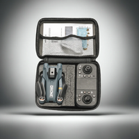 Gray travel case with electronic devices and accessories on a gradient background