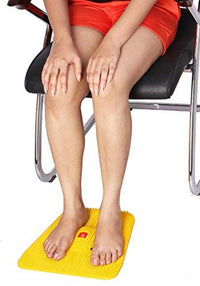 Person sitting on a chair with a yellow footrest on a white background